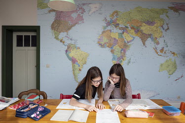 Twins Billie and Suzanne studying in the kitchen, which the family has been turned into a classroom, assignments sent, via the internet, by their school teacher. In the morning they study, in the afte...