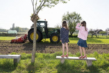 Billie and Suzanne watching a tractor ploughing the meadow adjacent to their house.  When Belgium followed much of the rest of the world into lockdown, Nick Hannes, like many Panos photographers, foun...