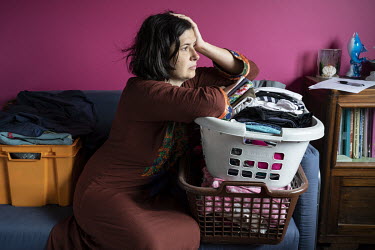 Anja, who works part-time night shifts in a residential home for people with severe mental and physical handicaps, with a basket of laundry.  When Belgium followed much of the rest of the world into l...