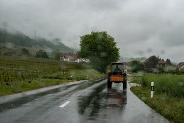 A farmer drives a tractor along a rural road in the rain, passing vineyards, in the first week of a three stage process of de-confinement after six weeks of lockdown. Vinyards have a staff shortage du...