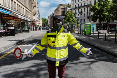 A lollipop man (crossing attendant) helping children going to school on the first day that shops and restaurants opened after eight weeks of lockdown.