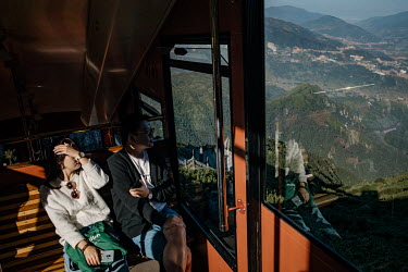 A couple travel on a tram that will take them to the foot of Mount Fansipan where a cable car transports passengers near to the peak of Mount Fansipan. The tram and cable car was completed in February...