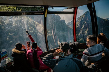 Passengers taking in views of the Hoang Lien Son mountain range while on a 6282m-long cable car ride to Mount Fansipan. Built in February 2016 the cable car starts its journey from the foot of the mou...