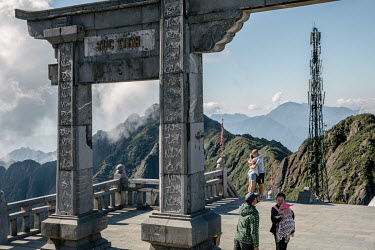 Tourists at a Buddhist Pagoda near the peak of Mount Fansipan (Phan Xi Pang) where a mobile phone mast vies for prominence.