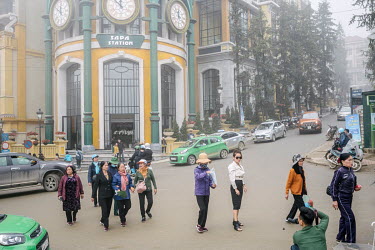 A Vietnamese tourist posing for photographs in front of Sapa railway station in the centre of the town.