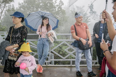 Vietnamese tourists at the top of Ham Rong (Dragon) Mountain on a foggy day. They are waiting for the weather to clear to get better views of the city.