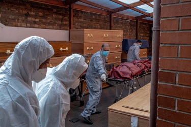 Funeral Director Javid Akhtar, with the help of volunteers from the local community, moves a body, collected from a local hospital, to the washing room at the Ghamkol Sharif mosque in Small Heath. A t...