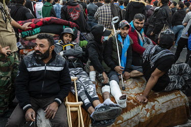 Anti-government protesters, some with injuries, rest near a barricade on Jumhuriyah bridge in the city centre, the scene of a standoff between protesters and security forces that has gone on for weeks...