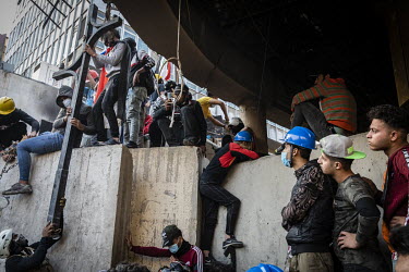 Youths climb on blast walls on Rasheed Street during clashes with security forces.   Since the beginning of October 2019 huge anti-government protests have shaken the country. People demanding reforms...