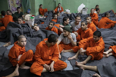 Young boys, many under the age of 16, sit in the crowded cell where they are being held at a prison for former ISIS members run by Kurdish forces in northeast Syria.