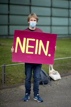 A student environmental activist holds a sign that reads: 'NEIN' during a protest against the startup of the coal-fired power plant Datteln 4 outside the Finnish Embassy. The Finnish energy group Unip...