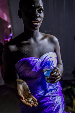 Hajarah, a contestant in the Y+ beauty contest, prepares to take her antiretroviral medication backstage on final's night. The Y+ beauty contest is national competition with the message that people wi...