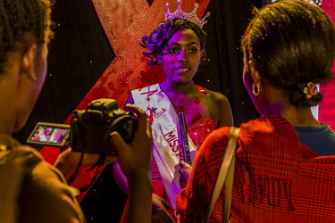 Vivian, the female winner of the Y+ beauty contest is interviewed by a local television station at the end of the night. The Y+ beauty contest is a national competition with the message that people wi...