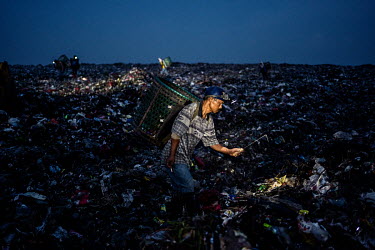 A trash picker looks for recyclable plastic and other items amongst freshly dumped trash from Jakarta at the Bantar Gabang landfill.