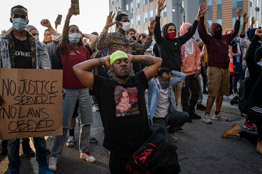 Demonstrators raise their hands and 'take a knee' during protests that resulted from the killing by the police of George Floyd, an unarmed African-American.