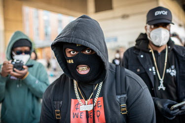 A demonstrator, wearing a balaclava, smiles to reaveal their gold teeth, during protests that resulted from the killing by the police of George Floyd, an unarmed African-American.