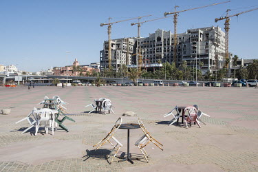 Outside tables along the Mediterranean coast, with a construction for an unfinished coastal hotel where work was halted because of the war.
