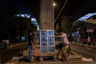 A community pantry being installed under an expressway in the Din Daeng district. The community pantry was started by a volunteer group called Little Bricks. Supakit 'Bank' Kulchartvijit said he model...