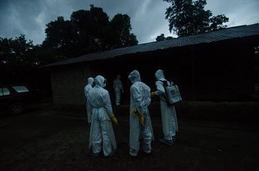 Ebola burial workers collect the body of an Ebola victim from a vilage near Kailahun.