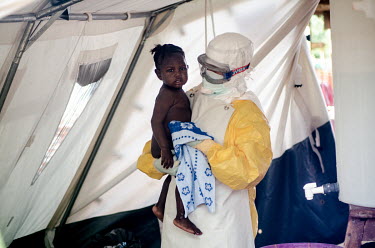 A baby who survived Ebola is carried out of the red zone at a treatment centre in Kailahun.