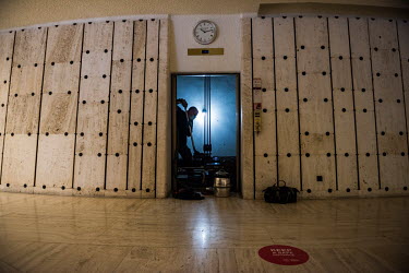 A member of staff cleaning an elevator, with a sign on the ground for keeping social distance. Preparations at the Palais des Nations, the UN office in Geneva (UNOG), are being made to reopen the buil...