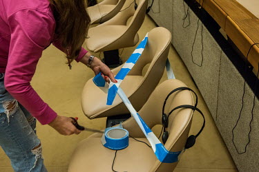 A conference officer uses tape to block off seating to allow each participant two metres of elbow space. Preparations at the Palais des Nations, the UN office in Geneva (UNOG), are being made to reope...