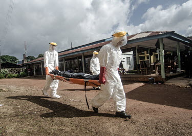 Ebola workers carry the body of an Ebola victim to the morgue at Kenema Government Hospital.