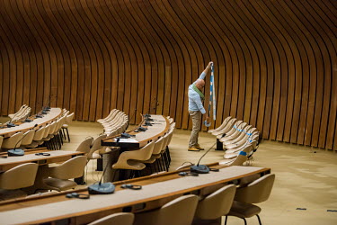A conference officer uses tape to block off seating to allow each participant two metres of elbow space. Preparations at the Palais des Nations, the UN office in Geneva (UNOG), are being made to reope...