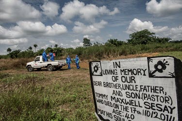 An Ebola burial team inter the body of an Ebola victim in a graveyard near Makeni.