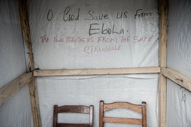 Graffiti reads: 'God Save us from Ebola', on the tarpaulin wall of an abandoned security booth at the entrance to Kenema government hospital.