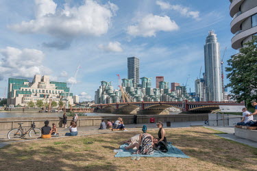 Londoners observing social distancing as they sit in the sunshine along the South Bank of the River Thames following some easing of the coronavirus lockdown measures by the government. Vauxhall Bridge...