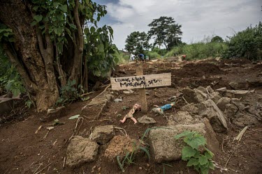 Dolls lie at the foot of the grave of a suspected Ebola victim in a cemetery in Freetown.
