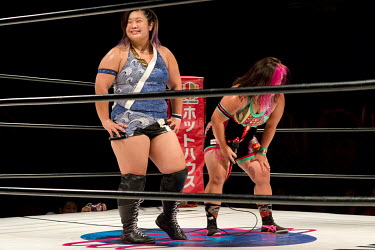 Yu (blue) smiles as she stands in the ring beside her opponent Chihiro Hashimoto after their bout at a women's wrestling competition held at the Shin-Kiba 1st Ring in the Shinkiba district.