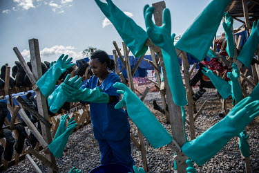 An Ebola worker hangs up rubber gloves to dry at a treatment centre in Kenema.