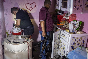 Members of a specialised police narcotics unit search the house of a known drug dealer after a raid aimed at capturing the suspect failed when the man escaped before the police arrived.
