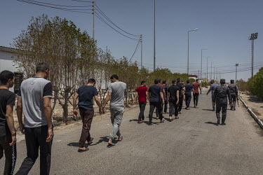 Inmates are escorted back to their living quarters at a special rehabilitation prison for drug addicts arrested and convicted as a result of operations targeting the illegal drug trade in southern Ira...