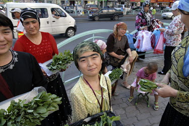 Uighur street traders selling salad and dresses on the pavement in the city centre.