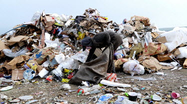 A person sifts through rubbish at the Red Rock dump looking for items to sell on to recyclers.