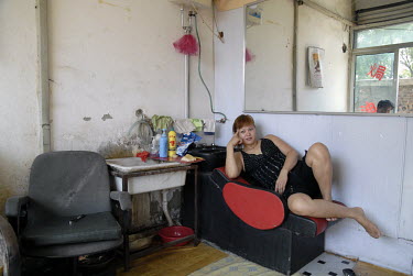 A sex worker waits for clients in a barber's shop. A lot of hairdresser's salons are hidden brothels, where men can have massages and paid sex.