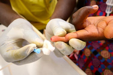 A pin prick is used to get a sample of blood from a pregnant woman which will be tested for HIV at the 'Ceu e Terras' health centre.