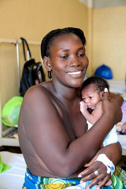A mother holds her new born baby on a maternity ward at the Simao Mendez central hospital.