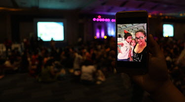 A mobile phone displays a picture of a woman and children at the 'Hakab Na!' (Big Latch On!), an annual event promoting breastfeeding that draws over 2000 mothers accompanied by their husbands and chi...