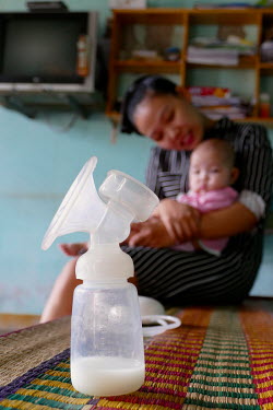 Huynh Thi Niem uses a breast pump to collect expressed milk at her home which she then donates to the Da Nang Milk bank.