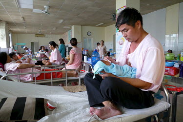 Phan Xuan Tuan (46) feds his baby at the Da Nang hospital for women and children with milk from the hospital's milk bank in a maternity ward.