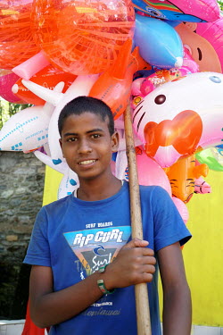 A boy sells balloons beside a boating lake at the Tal Barahi Temple.