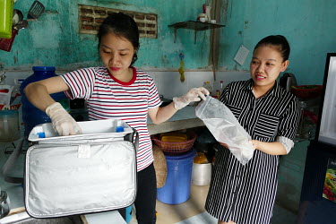 A representative of the Da Nang milk bank collects milk expressed by Huynh Thi Niem.