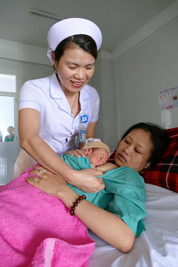 A nurse helps Phá��m Ly Na breastfeed her baby soon after giving birth in the Department of Obstetrics & Gynaecology at Quang Nam General Hospital.