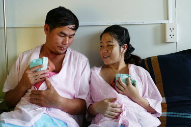 Nguyen Thi Bich Van (39) and her husband Phan Xuan Tuan (46) with their twin new born babies at the Da Nang hospital for women and children.