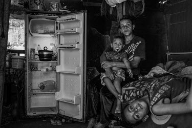 Rosangela da Silva, 36, with her son Artur, 3, and Diogo, 7, next to their almost empty refrigerator inside their shack on the outskirts of Sao Paulo. Rosangela is unemployed and living in extreme pov...