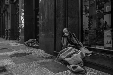 A street dweller wears a mask to protect himself from Covid-19 on a street in downtown Sao Paulo. The Covid 19 pandemic has caused many charities looking after homelss people to stop operating and wit...